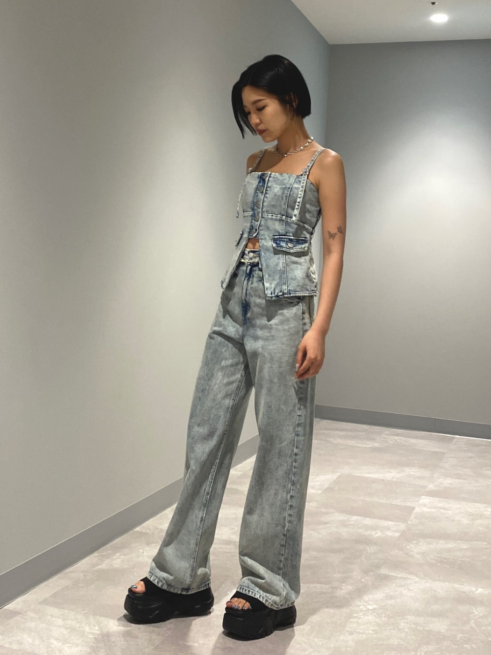 ブラック系のサンダル、ブルー系のデニムパンツ、ブルー系のキャミソールを着用したレディースの夏コーディネートの2枚目の写真