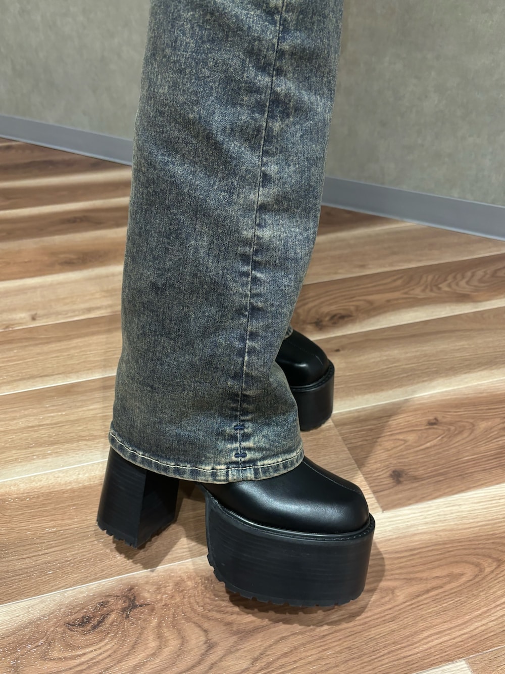 グレー系のブルゾン、ホワイト系のニット/セーター、ブルー系のデニムパンツを着用したレディースの秋コーディネートの6枚目の写真