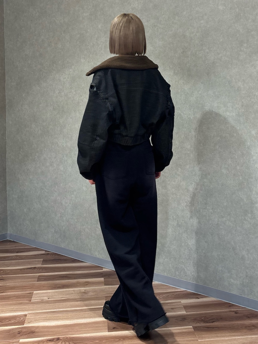 ブラック系のブーツ、ブラック系のブルゾン、ホワイト系のニット/セーターを着用したレディースの秋コーディネートの3枚目の写真