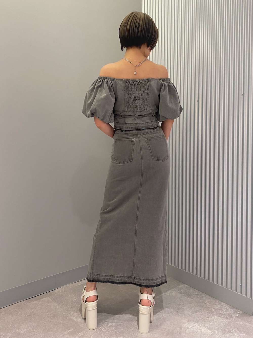 グレー系のシャツ/ブラウス、グレー系のスカート、ホワイト系のサンダルを着用したレディースの春コーディネートの3枚目の写真