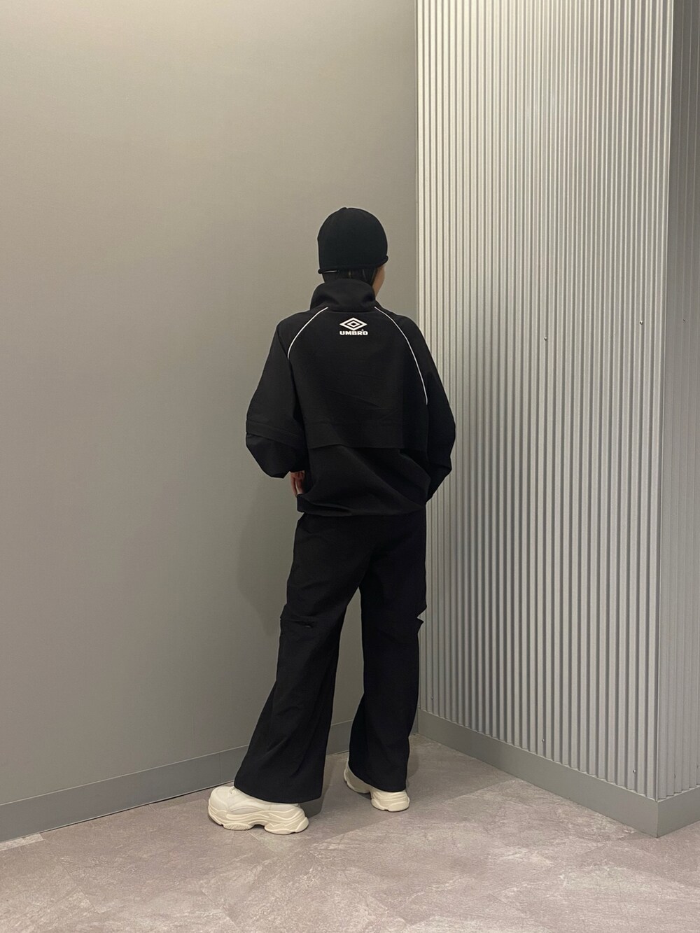 ホワイト系のスニーカー、ブラック系のその他パンツ、ブラック系のブルゾンを着用したレディースの春コーディネートの2枚目の写真