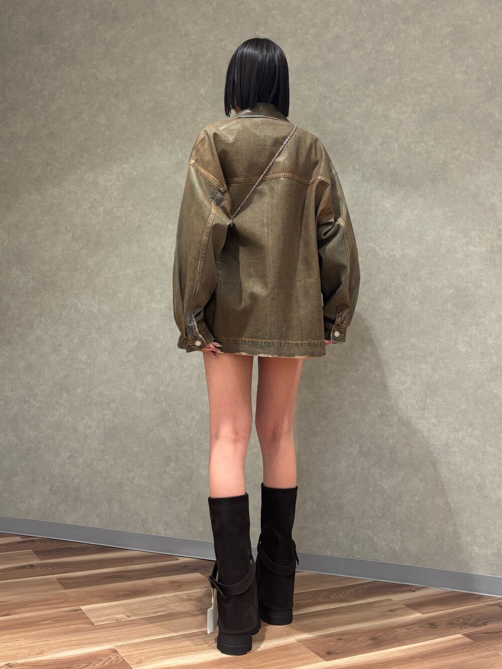 ブラック系のブーツ、ブラウン系のスカート、ブラウン系のブルゾンを着用したレディースの冬コーディネートの3枚目の写真