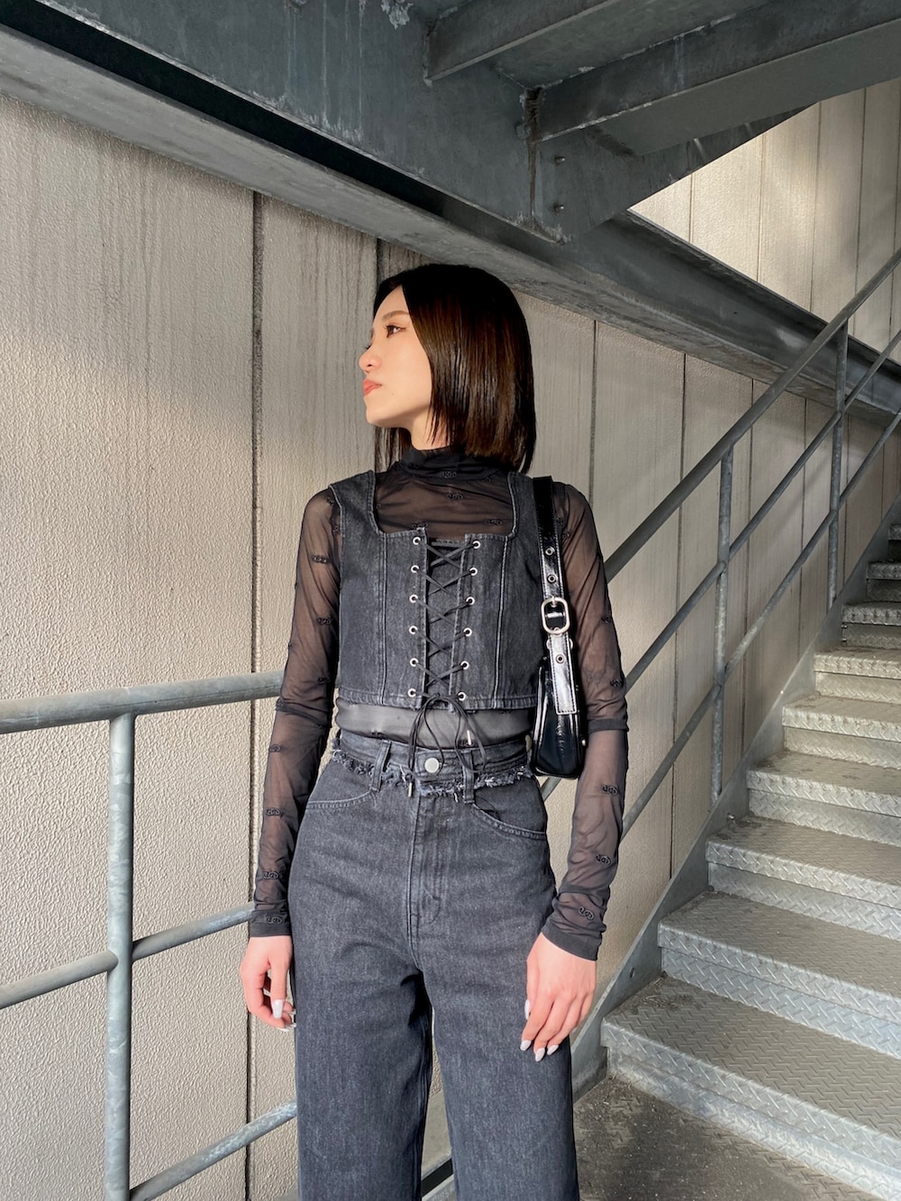 ブラック系のデニムパンツ、グリーン系のパンプス、ブラック系のその他トップスを着用したレディースの春コーディネートの4枚目の写真