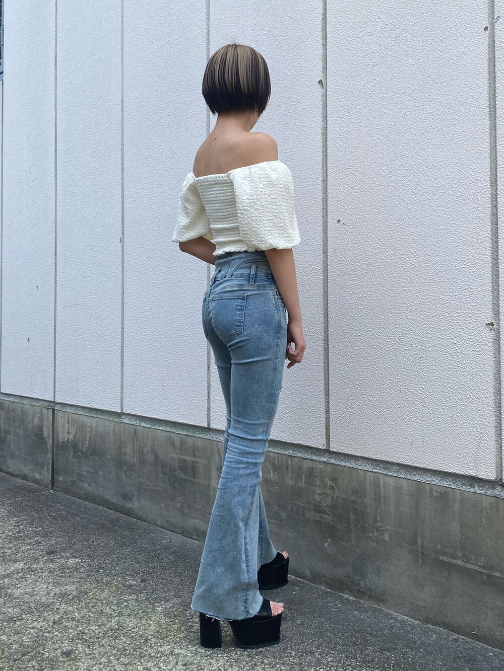 ブラック系のサンダル、ブルー系のデニムパンツ、ホワイト系のTシャツ/カットソーを着用したレディースの春コーディネートの2枚目の写真