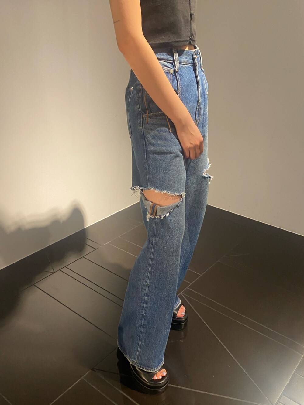 ブラック系のTシャツ/カットソー、ブルー系のデニムパンツ、ブラック系のサンダルを着用したレディースの夏コーディネートの4枚目の写真