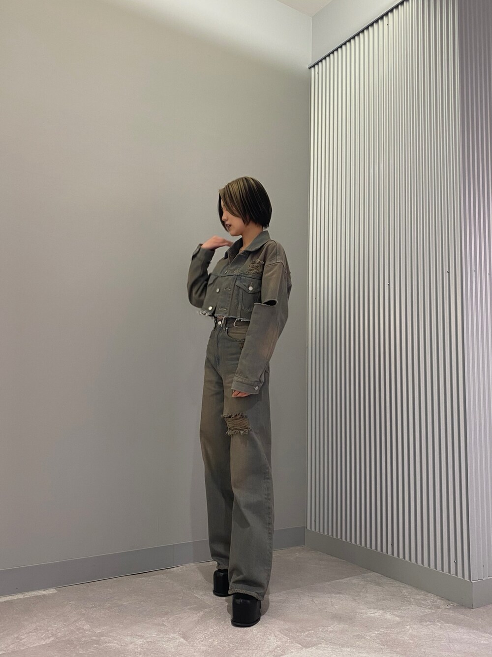 ブラック系のブーツ、グレー系のデニムパンツ、ブラック系のキャミソールを着用したレディースの冬コーディネートの2枚目の写真