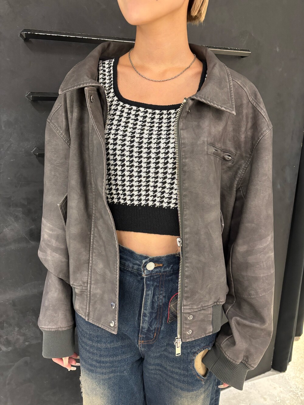 ブルー系のデニムパンツ、ブラック系のニット/セーター、グレー系のブルゾンを着用したレディースの秋コーディネートの4枚目の写真