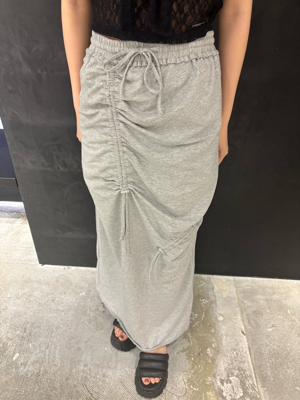 ブラック系のTシャツ/カットソー、グレー系のスカート、ブラック系のサンダルを着用したレディースの夏コーディネートの5枚目の写真