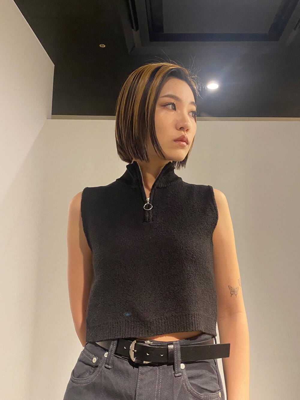 ブラック系のデニムパンツ、ホワイト系のサンダル、ブラック系のタンクトップを着用したレディースの春コーディネートの3枚目の写真