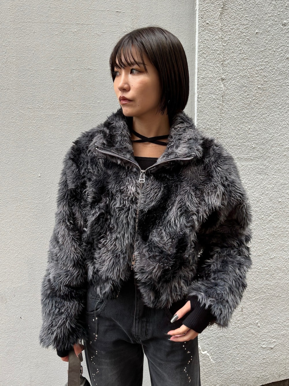 ブラック系のニット/セーター、ブラック系のデニムパンツ、その他のブルゾンを着用したレディースの秋コーディネートの4枚目の写真