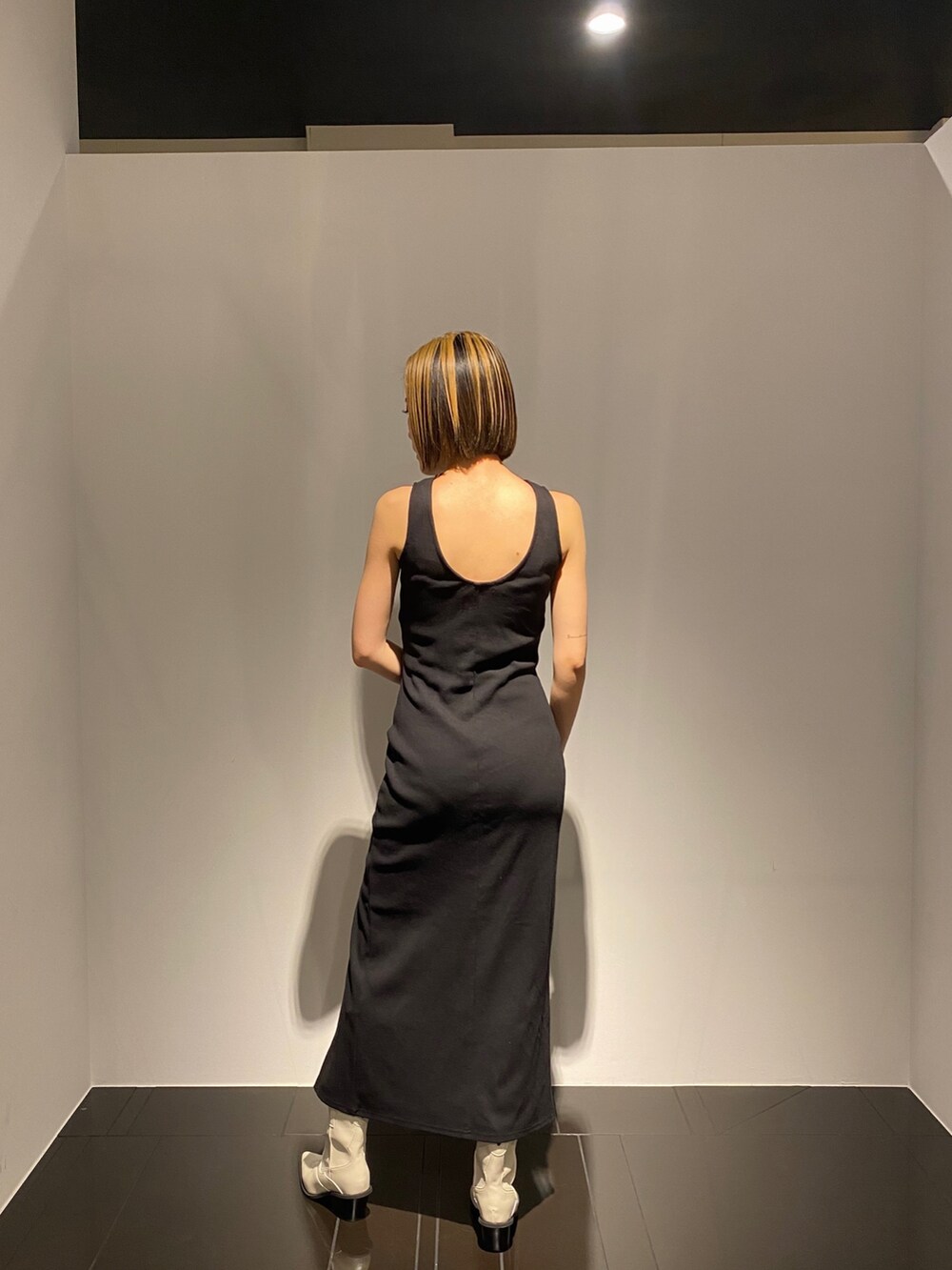 ホワイト系のブーツ、その他のハンドバッグ、ブラック系のワンピースを着用したレディースの春コーディネートの3枚目の写真