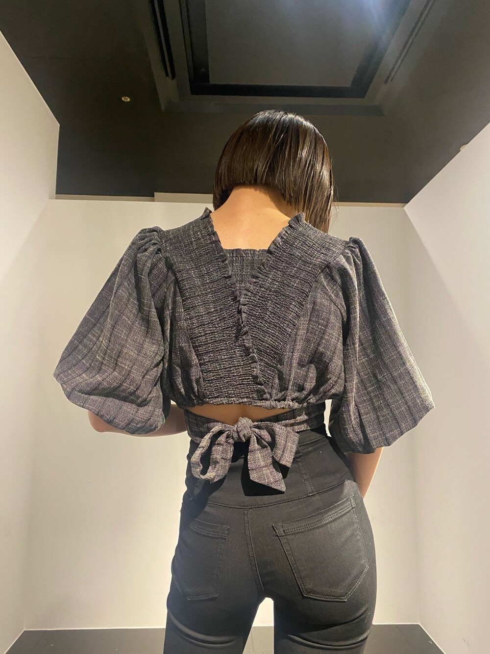 ブラック系のTシャツ/カットソー、ホワイト系のサンダル、ブラック系のデニムパンツを着用したレディースの春コーディネートの4枚目の写真