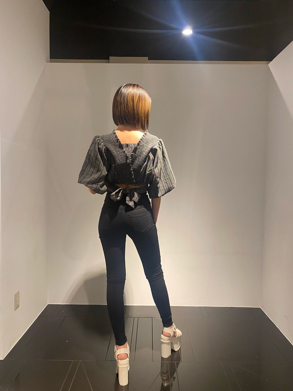 ブラック系のTシャツ/カットソー、ホワイト系のサンダル、ブラック系のデニムパンツを着用したレディースの春コーディネートの2枚目の写真