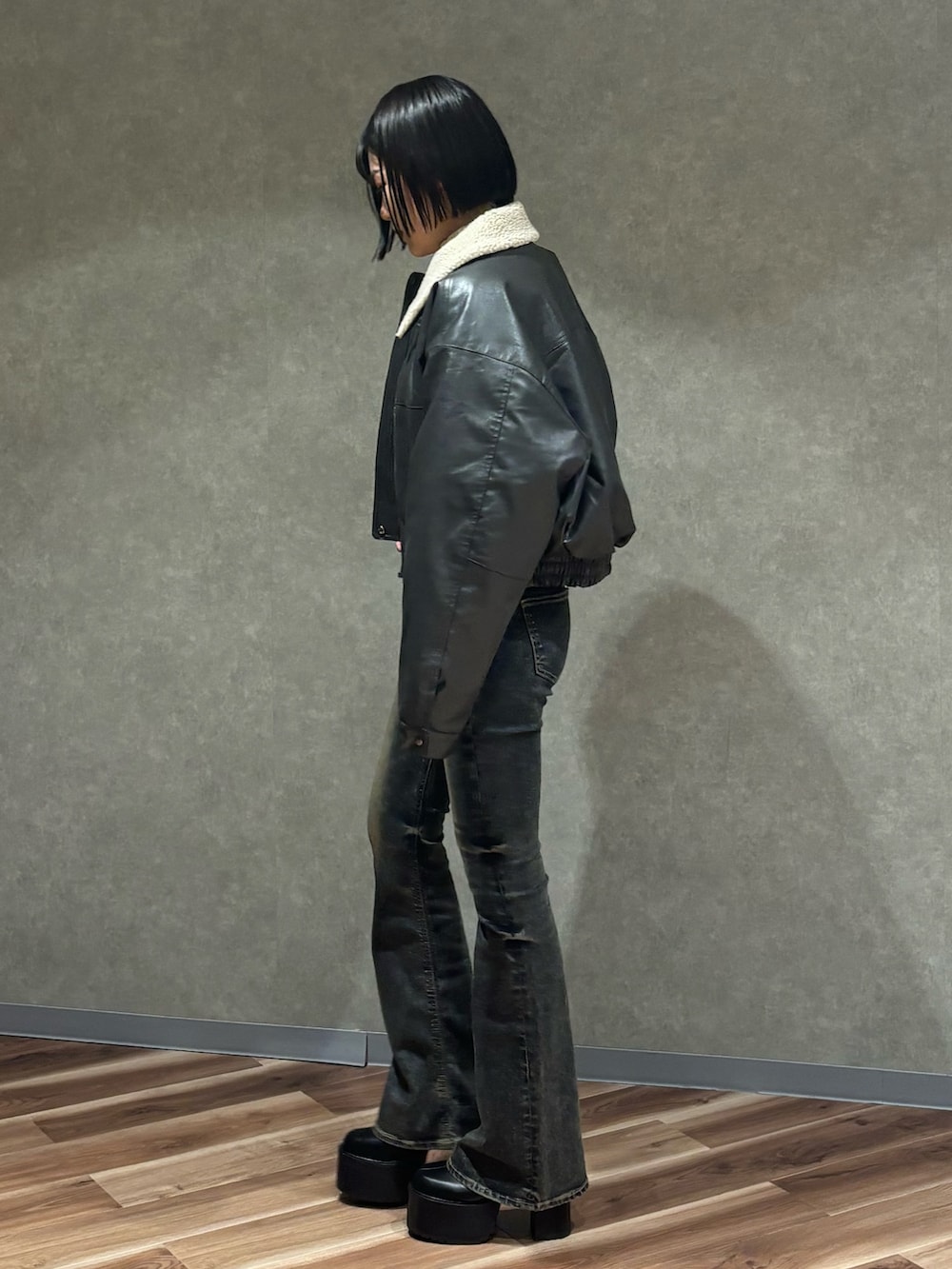 グレー系のブルゾン、ホワイト系のニット/セーター、ブルー系のデニムパンツを着用したレディースの秋コーディネートの2枚目の写真