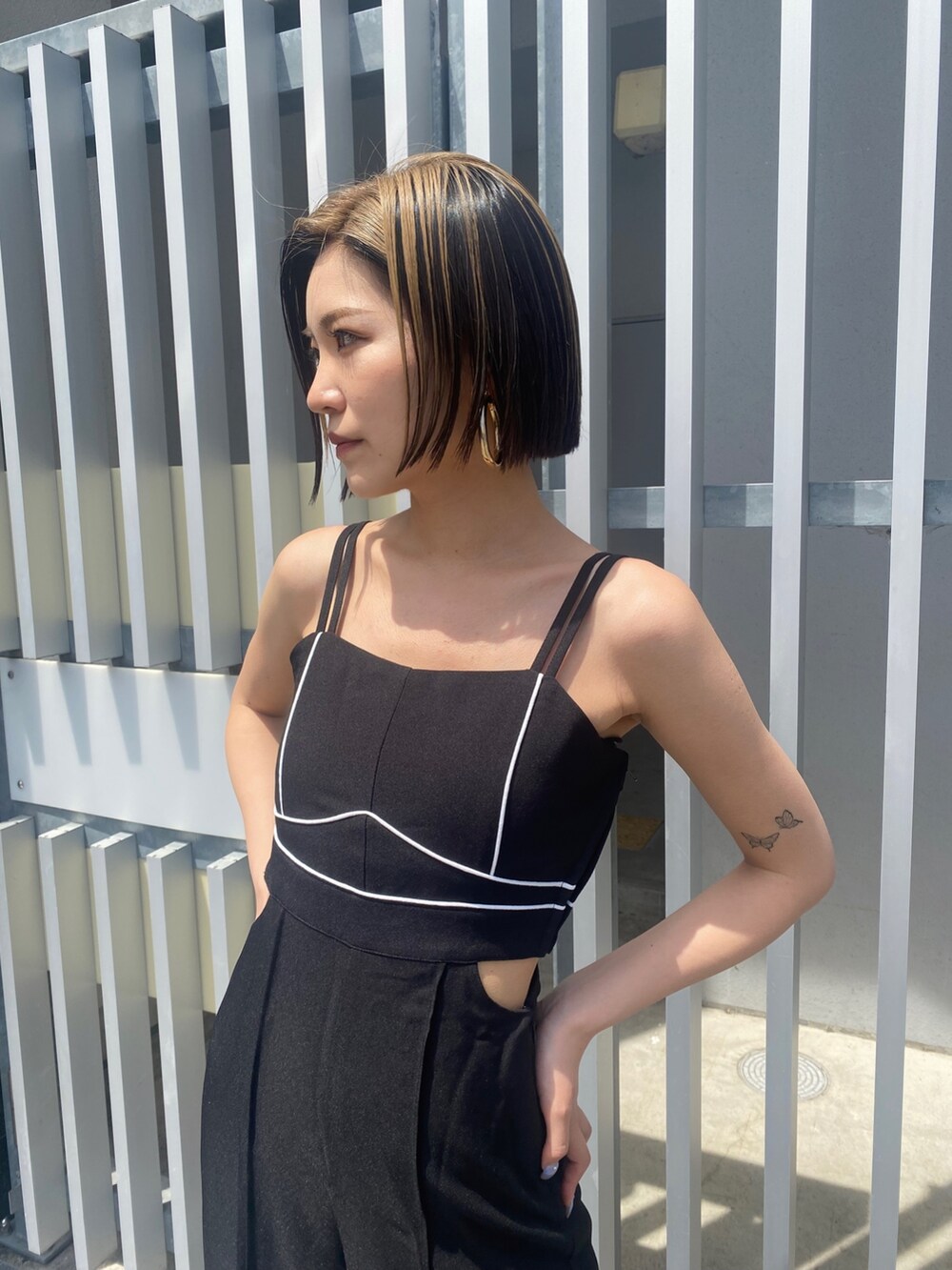 ブラック系のサロペット/オーバーオール、ホワイト系のサンダルを着用したレディースの夏コーディネートの3枚目の写真