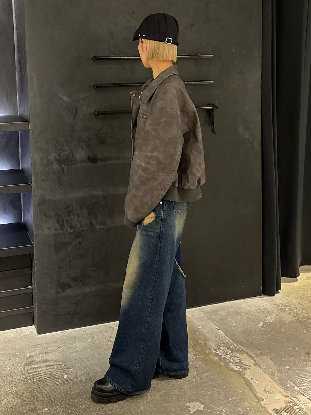 ブルー系のデニムパンツ、ブラック系のニット/セーター、グレー系のブルゾンを着用したレディースの秋コーディネートの2枚目の写真