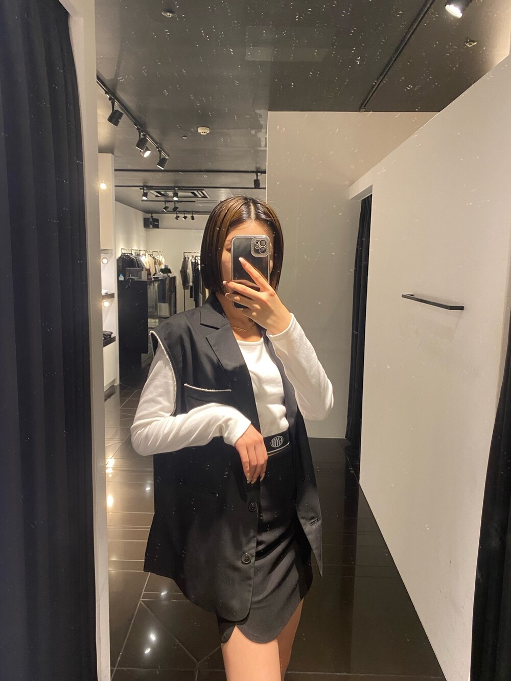 ホワイト系のTシャツ/カットソー、ブラック系のベスト、ブラック系のスカートを着用したレディースの夏コーディネートの4枚目の写真