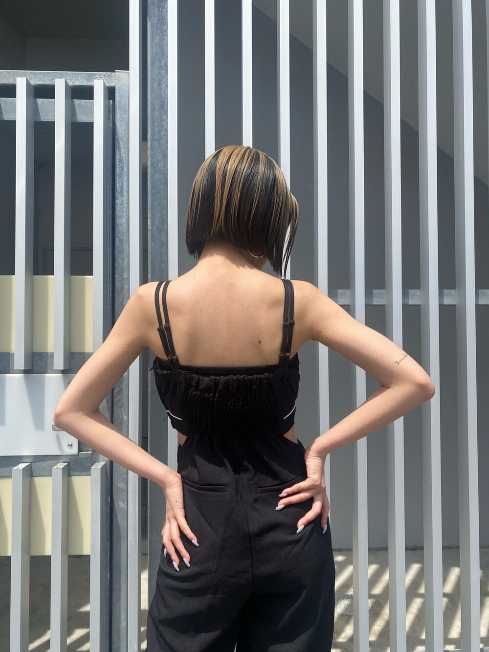 ブラック系のサロペット/オーバーオール、ホワイト系のサンダルを着用したレディースの夏コーディネートの5枚目の写真