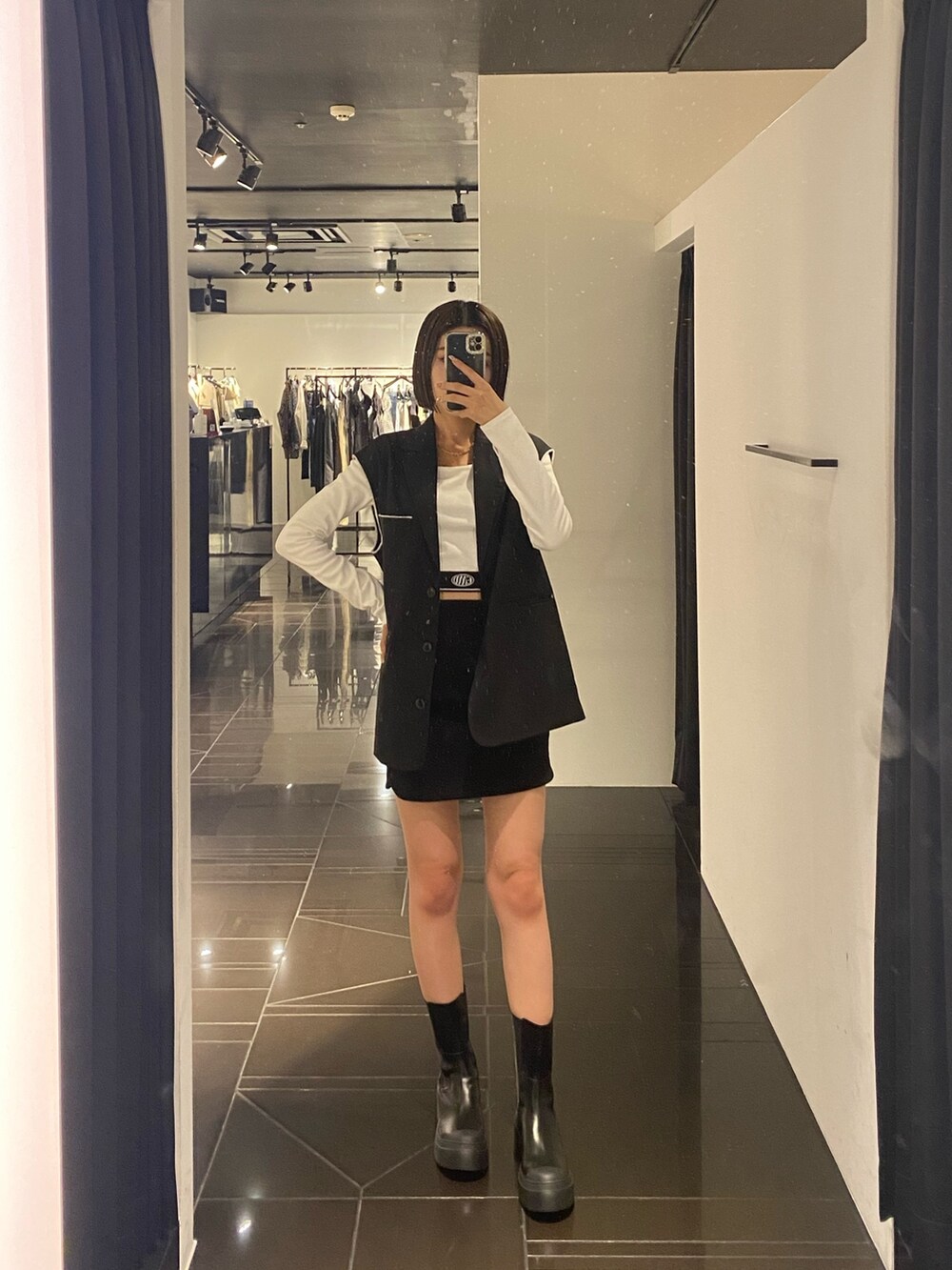 ホワイト系のTシャツ/カットソー、ブラック系のベスト、ブラック系のスカートを着用したレディースの夏コーディネートの2枚目の写真