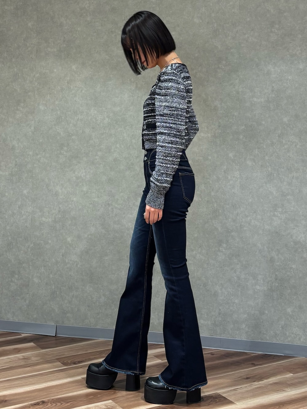 ブルー系のデニムパンツ、ブラック系のニット/セーター、ブラック系のブーツを着用したレディースの冬コーディネートの2枚目の写真