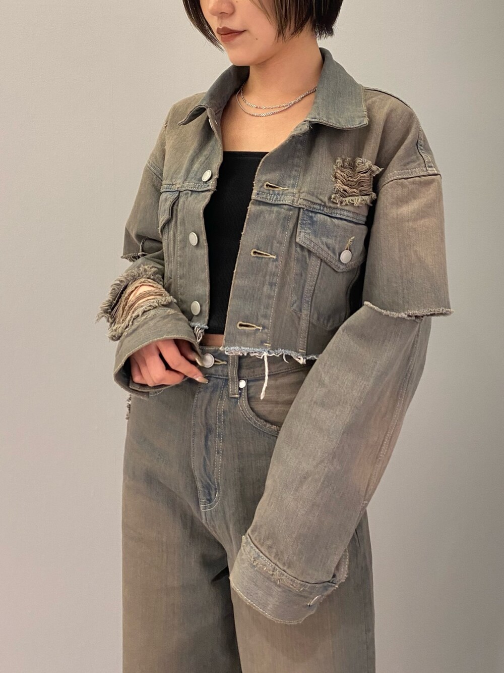 ブラック系のブーツ、グレー系のデニムパンツ、ブラック系のキャミソールを着用したレディースの冬コーディネートの3枚目の写真