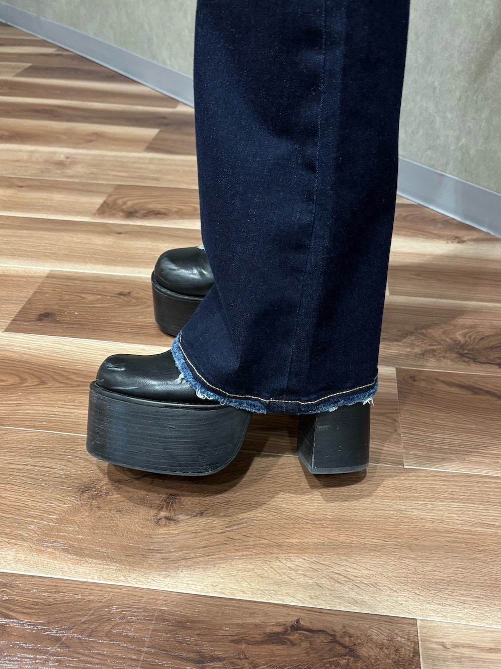 ブルー系のデニムパンツ、ブラック系のニット/セーター、ブラック系のブーツを着用したレディースの冬コーディネートの6枚目の写真