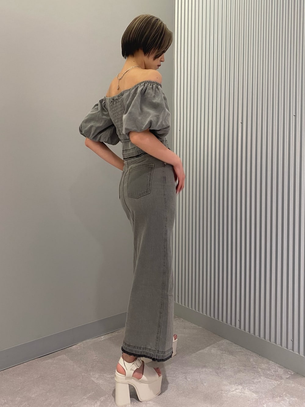 グレー系のシャツ/ブラウス、グレー系のスカート、ホワイト系のサンダルを着用したレディースの春コーディネートの2枚目の写真