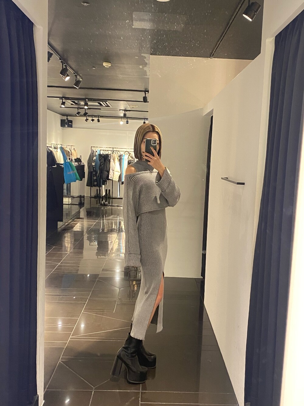 ブラック系のブーツ、グレー系のワンピースを着用したレディースの冬コーディネートの2枚目の写真