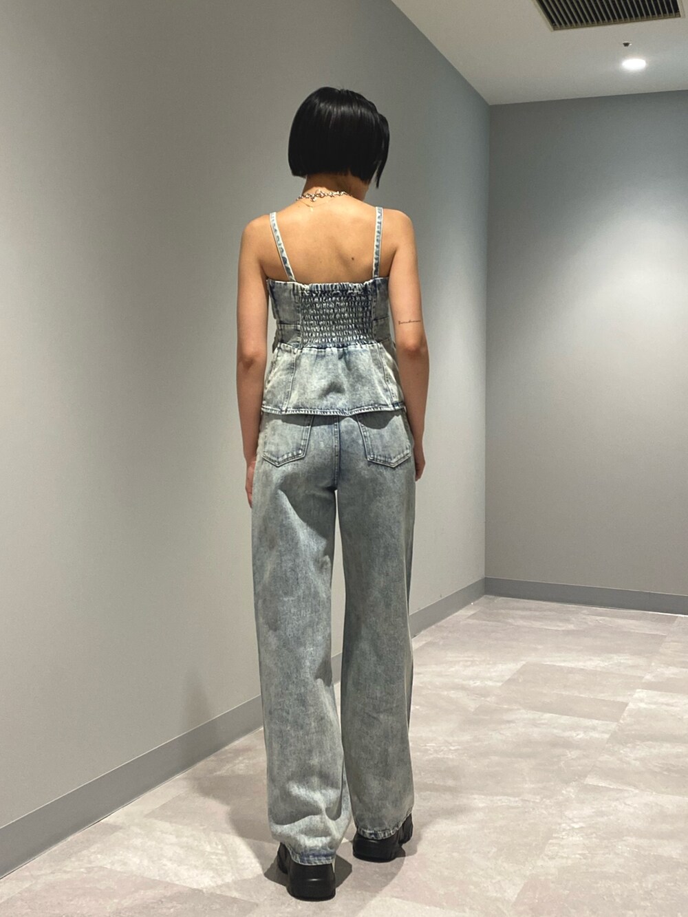 ブラック系のサンダル、ブルー系のデニムパンツ、ブルー系のキャミソールを着用したレディースの夏コーディネートの4枚目の写真