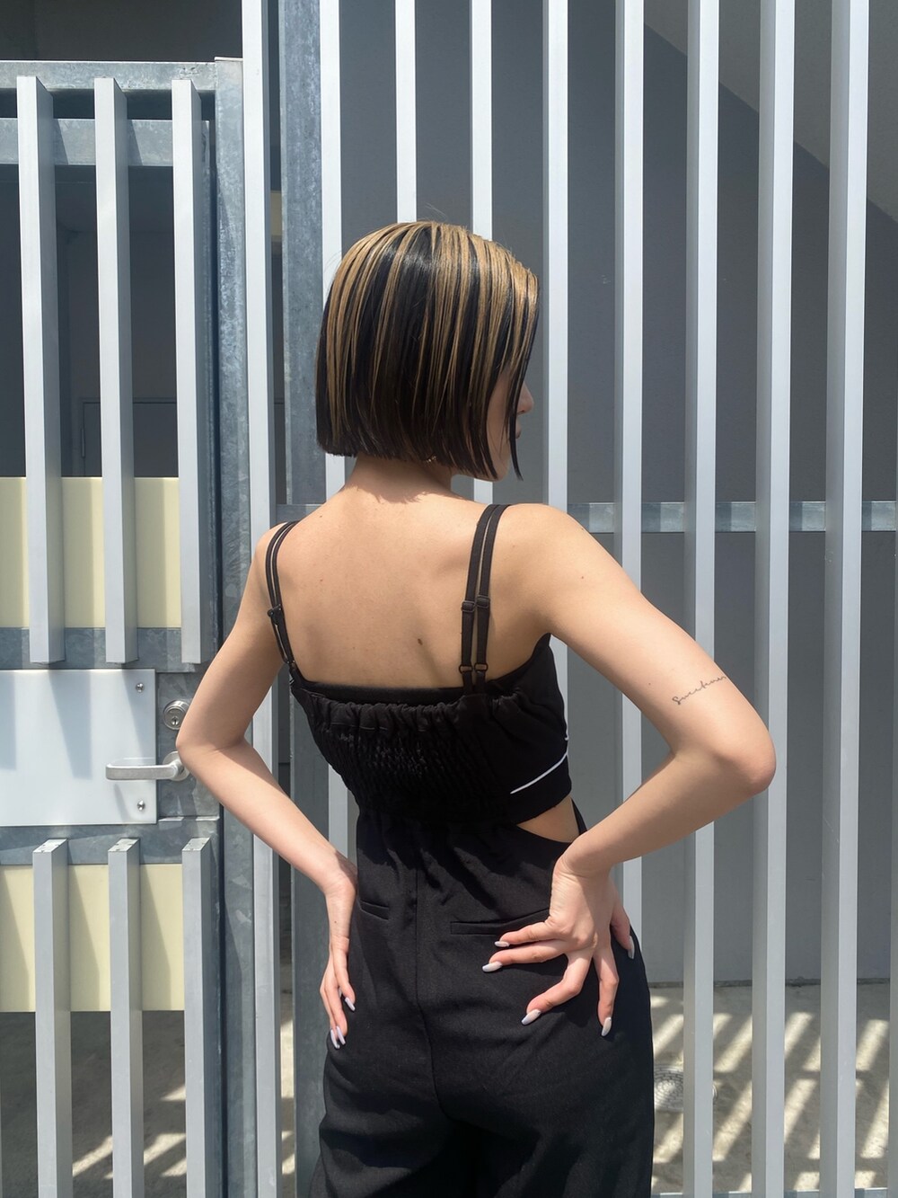 ブラック系のサロペット/オーバーオール、ホワイト系のサンダルを着用したレディースの夏コーディネートの4枚目の写真