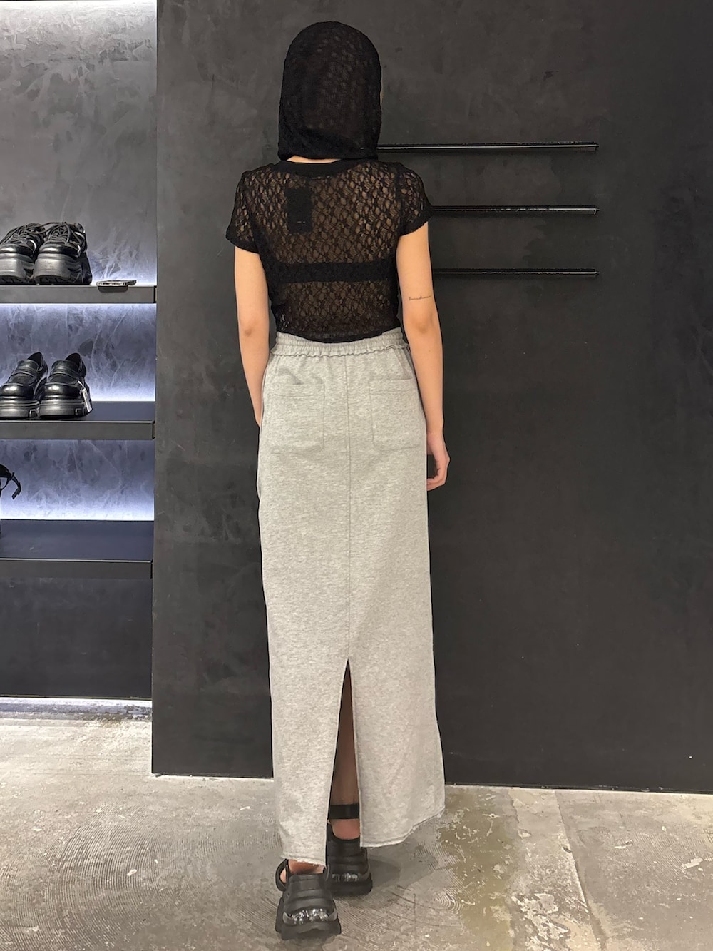 ブラック系のTシャツ/カットソー、グレー系のスカート、ブラック系のサンダルを着用したレディースの夏コーディネートの3枚目の写真