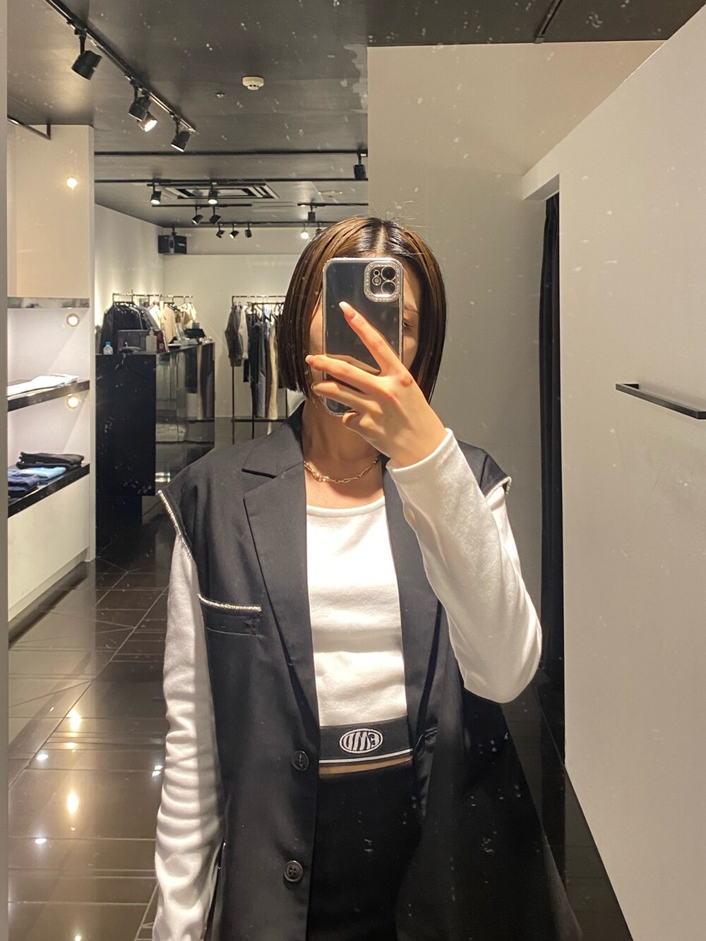 ホワイト系のTシャツ/カットソー、ブラック系のベスト、ブラック系のスカートを着用したレディースの夏コーディネートの5枚目の写真