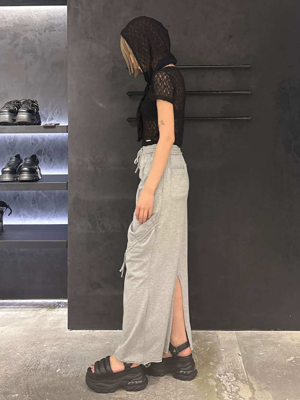 ブラック系のTシャツ/カットソー、グレー系のスカート、ブラック系のサンダルを着用したレディースの夏コーディネートの2枚目の写真