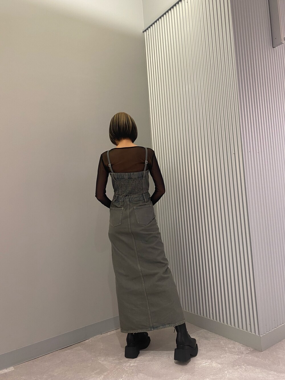 ブラック系のTシャツ/カットソー、ブラック系のブーツ、グレー系のワンピースを着用したレディースの春コーディネートの3枚目の写真