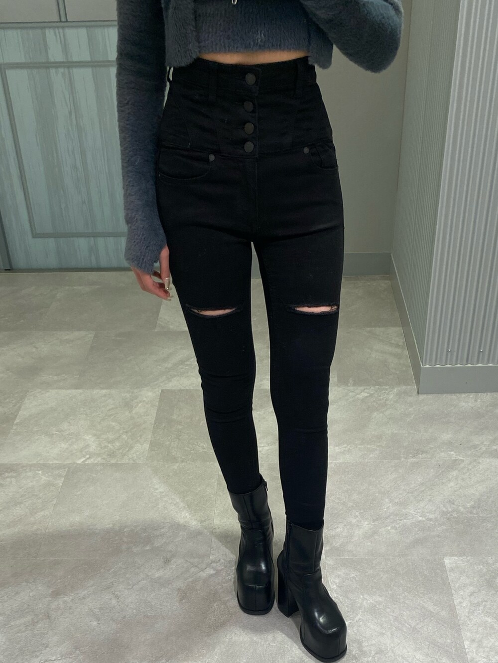 ブラック系のデニムパンツ、ブラック系のブーツ、グレー系のニット/セーターを着用したレディースの冬コーディネートの5枚目の写真