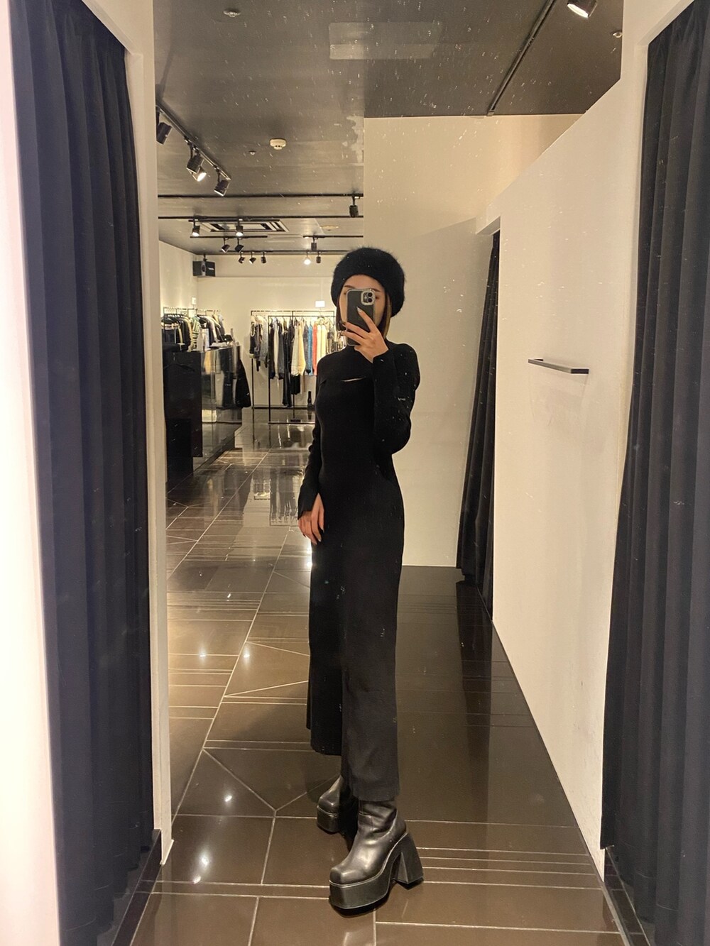 ブラック系のワンピース、ブラック系のブーツ、ブラック系のハンチング/ベレー帽を着用したレディースの冬コーディネートの2枚目の写真