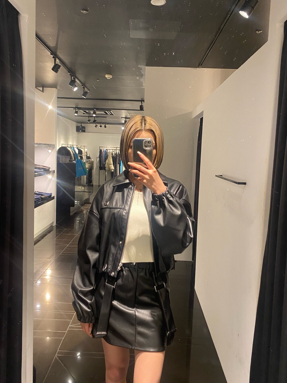 ブラック系のブーツ、ブラック系のスカート、ホワイト系のニット/セーターを着用したレディースの冬コーディネートの3枚目の写真