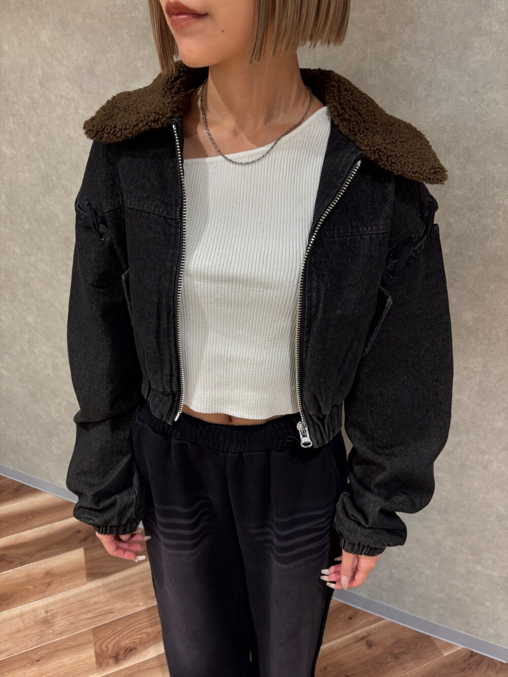 ブラック系のブーツ、ブラック系のブルゾン、ホワイト系のニット/セーターを着用したレディースの秋コーディネートの4枚目の写真