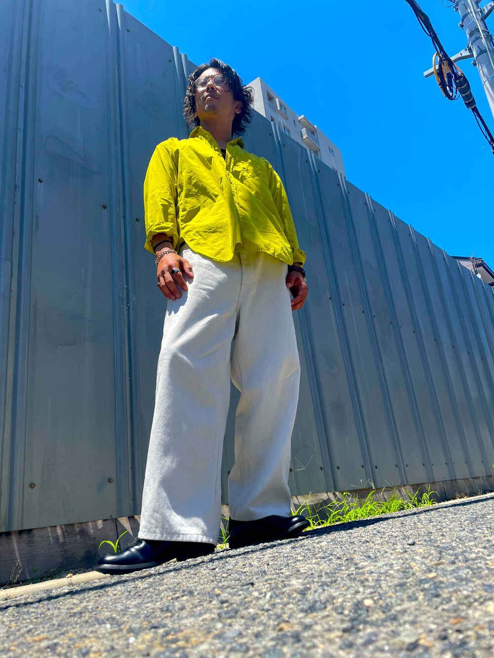 イエロー系のシャツ/ブラウス、ブラック系のローファー、ホワイト系のデニムパンツを着用したメンズの夏コーディネートの2枚目の写真