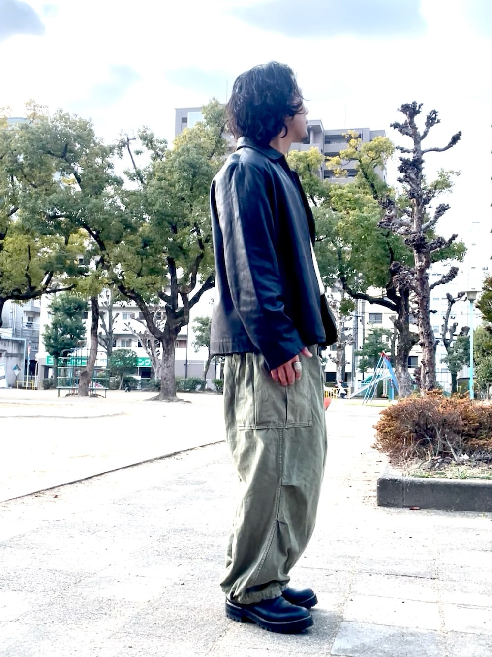 ベージュ系のニット/セーター、ブラック系のライダースジャケット、グリーン系のカーゴパンツを着用したメンズの冬コーディネートの3枚目の写真