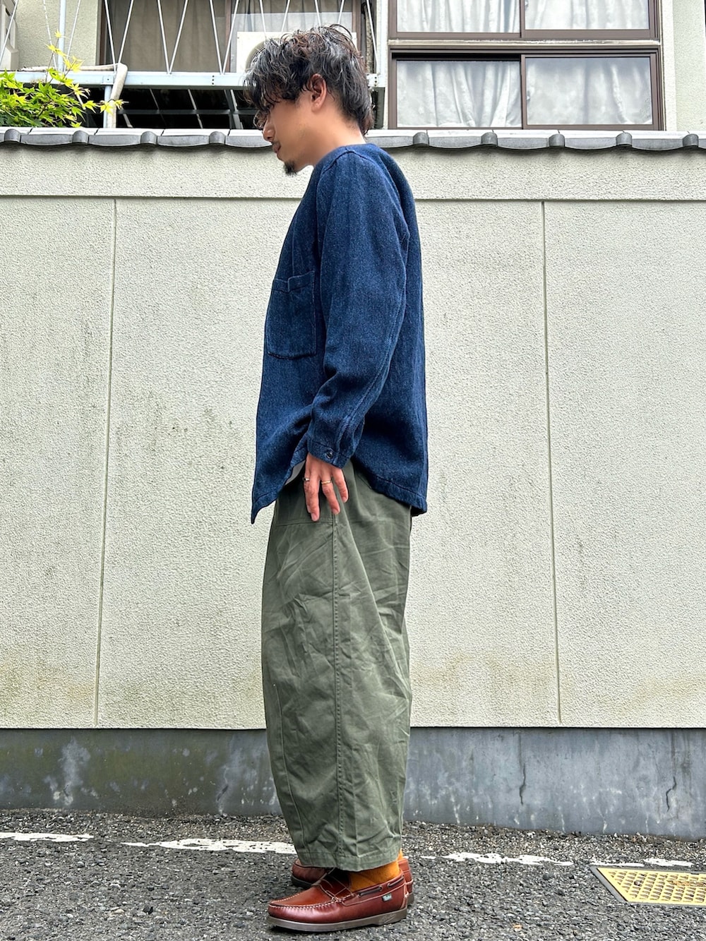 グリーン系のカーゴパンツ、ブラウン系のローファー、ブルー系のカバーオールを着用したメンズの春コーディネートの2枚目の写真