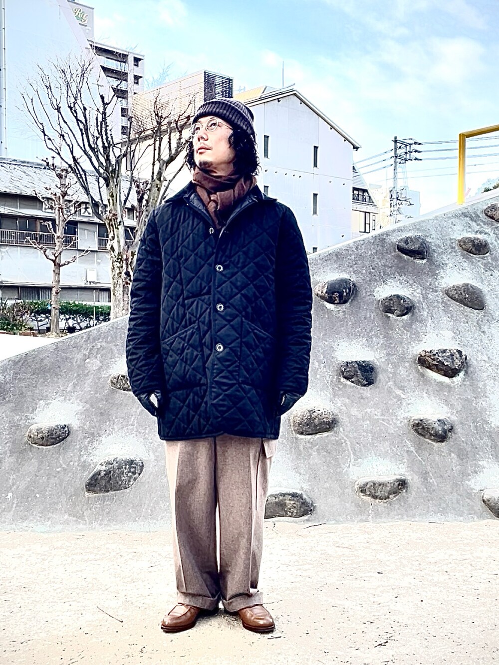 ベージュ系のカーゴパンツ、ブラウン系のローファー、ブラック系のダウンジャケット/コートを着用したメンズの冬コーディネートの2枚目の写真