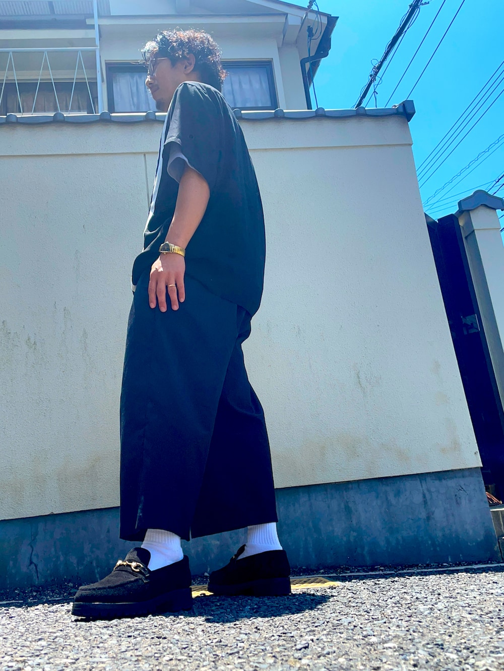 ブラック系のシャツ/ブラウス、ブラック系のローファー、ブラック系のスラックスを着用したメンズの春コーディネートの2枚目の写真