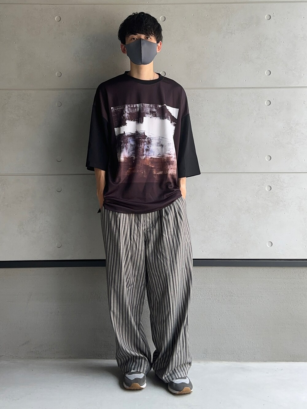 ブラック系のTシャツ/カットソー、グレー系のスラックスを着用したメンズの夏コーディネートの2枚目の写真