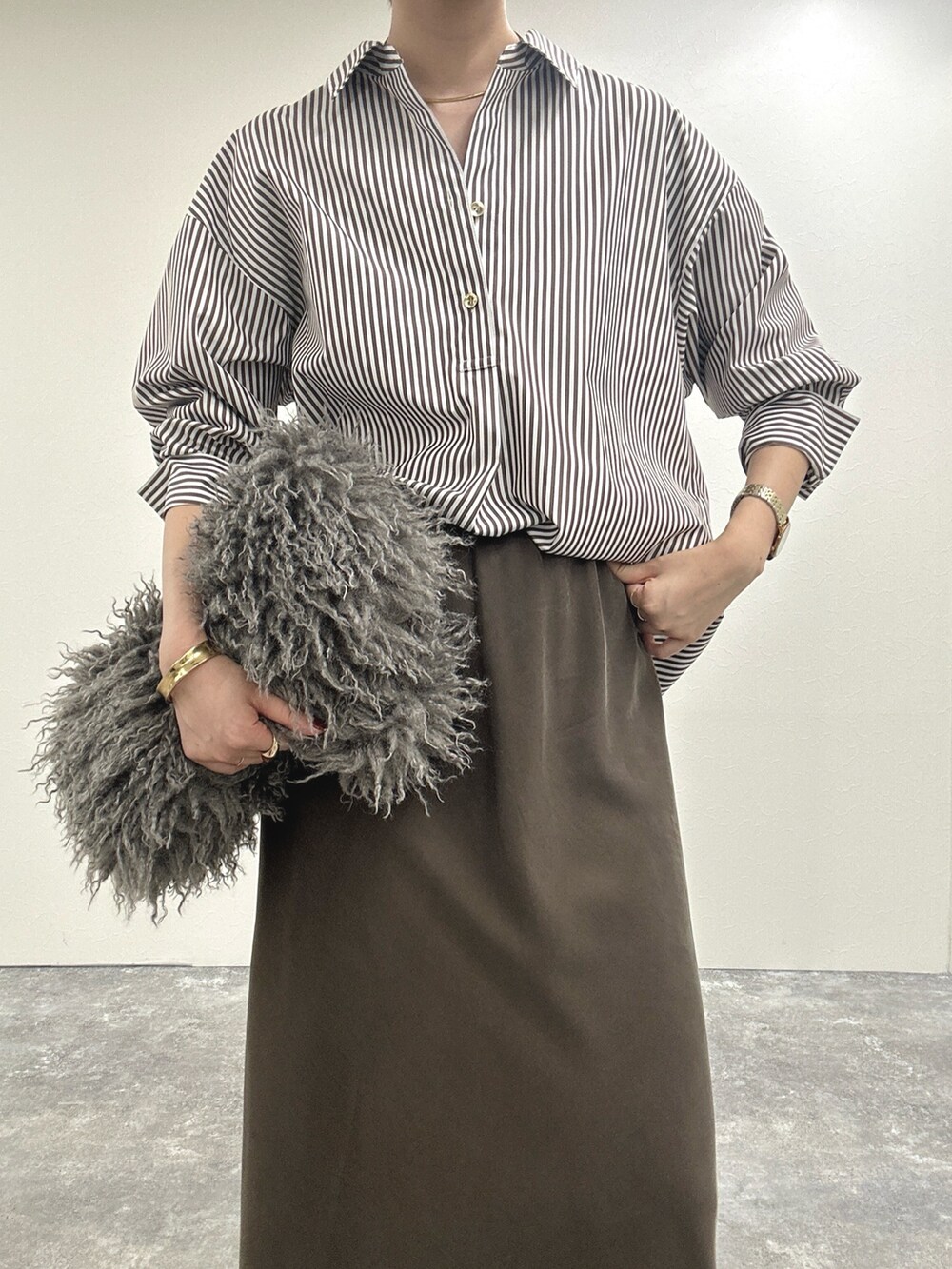 ブラウン系のシャツ/ブラウス、ブラウン系のスカート、ベージュ系のショルダーバッグを着用したレディースの秋コーディネートの10枚目の写真