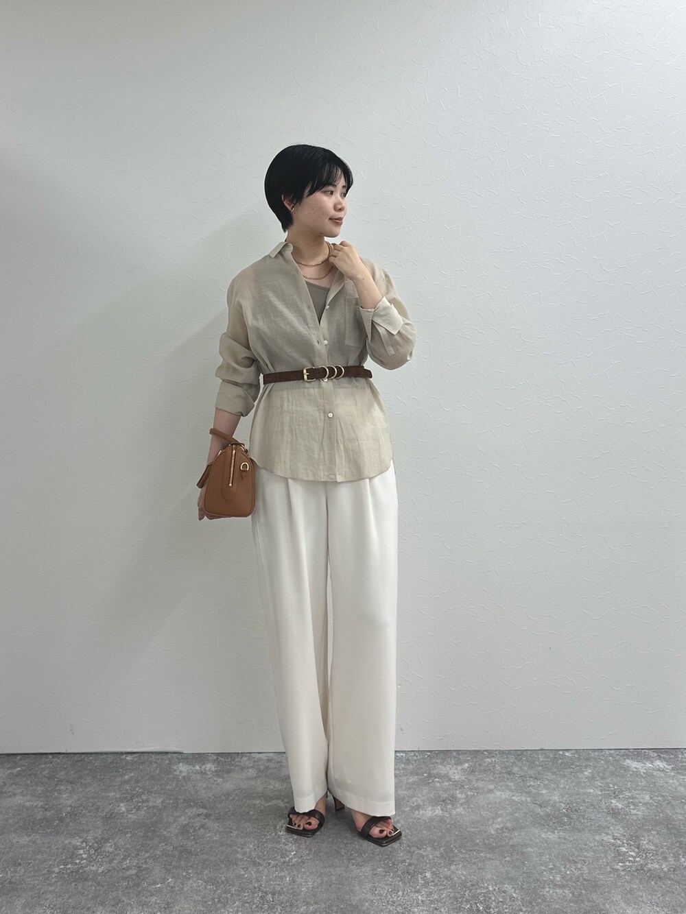 ベージュ系のシャツ/ブラウス、ホワイト系のその他パンツ、ブラウン系のボストンバッグを着用したレディースの春コーディネートの3枚目の写真