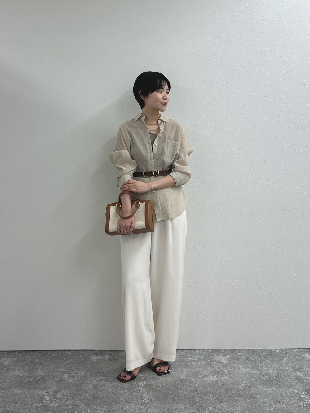ベージュ系のシャツ/ブラウス、ホワイト系のその他パンツ、ブラウン系のボストンバッグを着用したレディースの春コーディネートの6枚目の写真