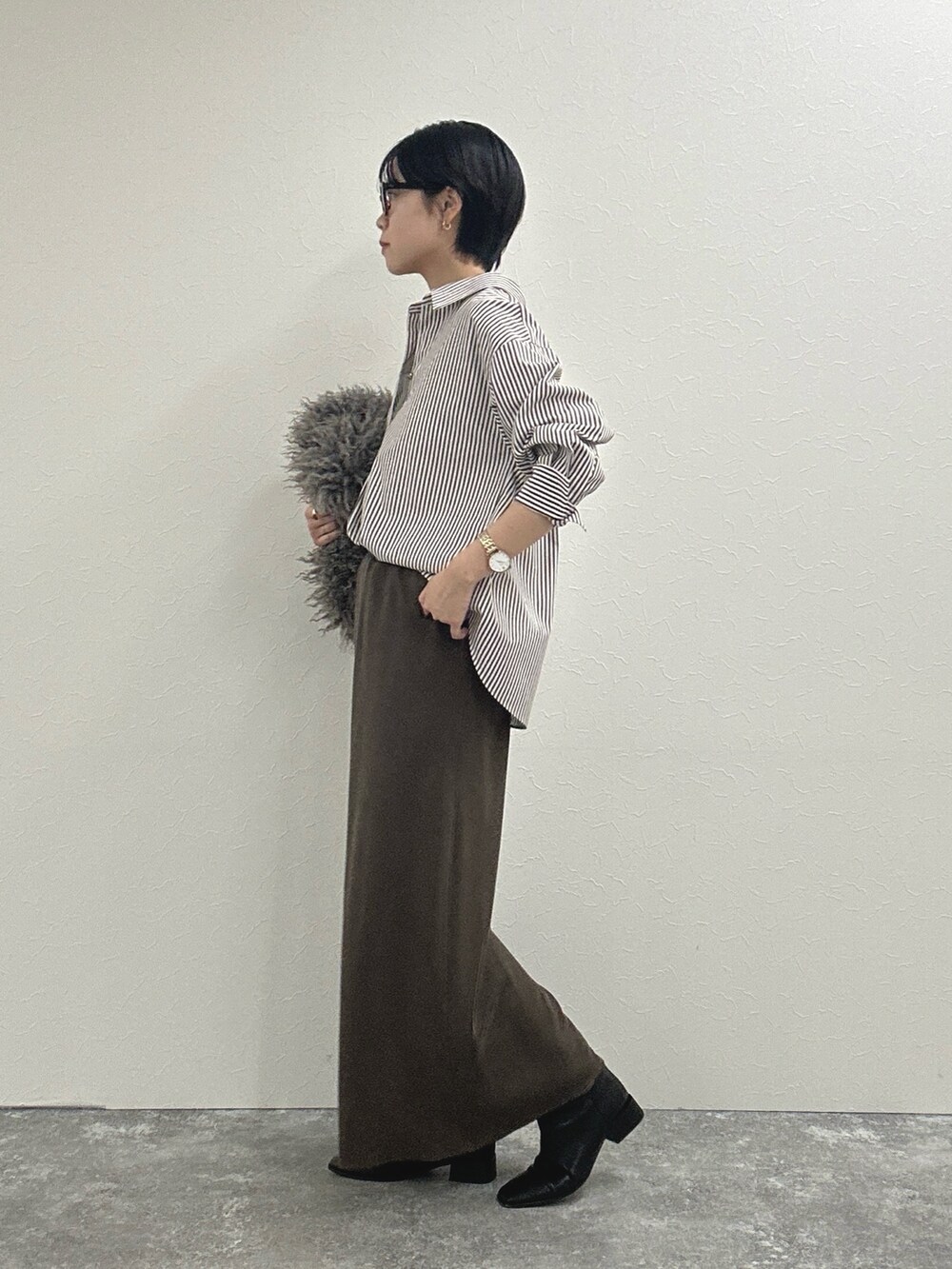 ブラウン系のシャツ/ブラウス、ブラウン系のスカート、ベージュ系のショルダーバッグを着用したレディースの秋コーディネートの7枚目の写真