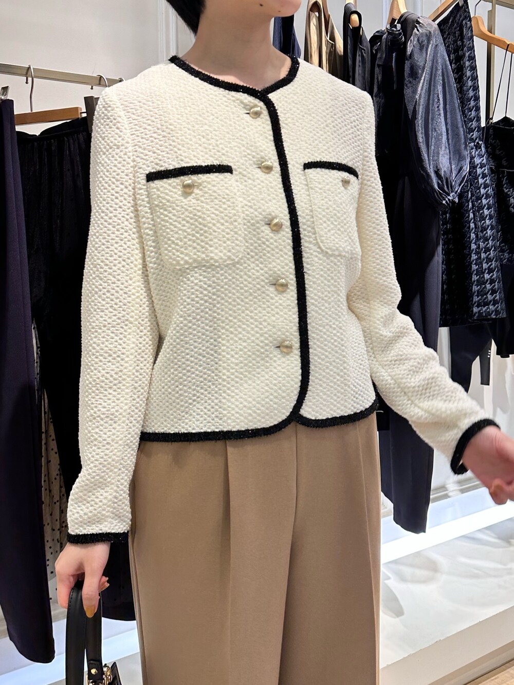 ホワイト系のノーカラージャケット、イエロー系のその他パンツ、ブラック系のショルダーバッグを着用したレディースの秋コーディネートの3枚目の写真