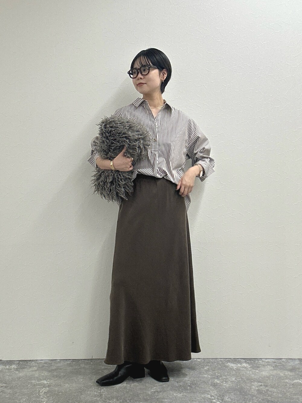 ブラウン系のシャツ/ブラウス、ブラウン系のスカート、ベージュ系のショルダーバッグを着用したレディースの秋コーディネートの5枚目の写真